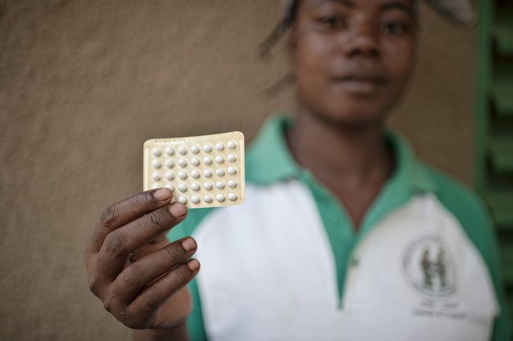 mujer sosteniendo pildoras anticonceptivas