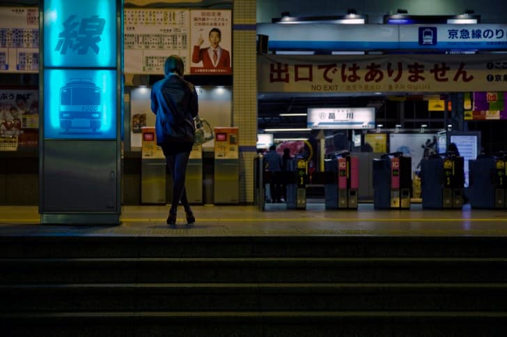 mujer solitaria esperando el metro por la noche